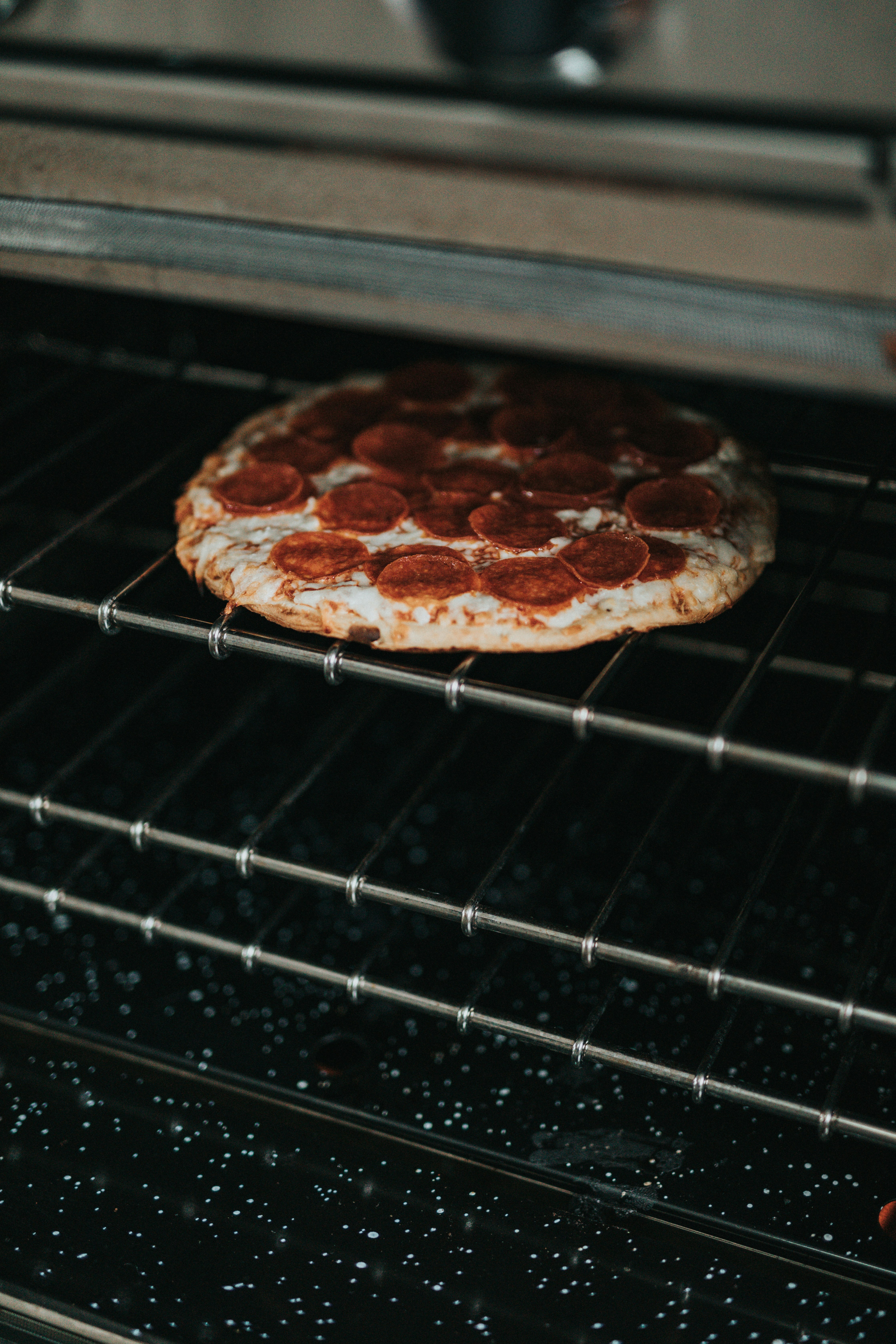 brown and white pizza on black metal grill